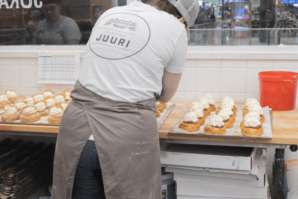 Leipomo Juuren työntekijä valmistaa laskiaispullia Tapiolan leipomossa.